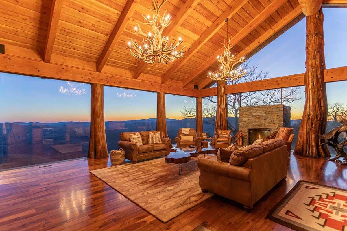 Living room at sunset with antler chandeliers and a stone fireplace