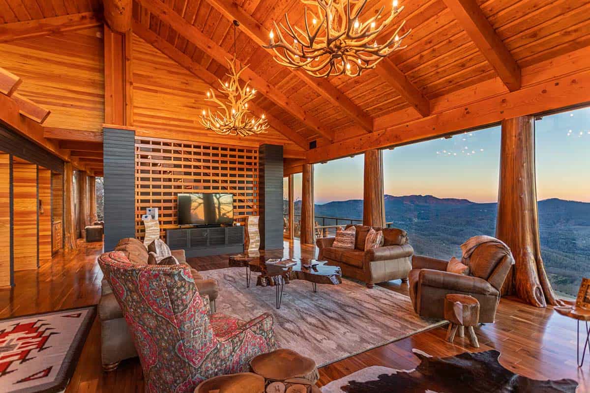 Living room at dusk with antler chandeliers and a wood lattice wall