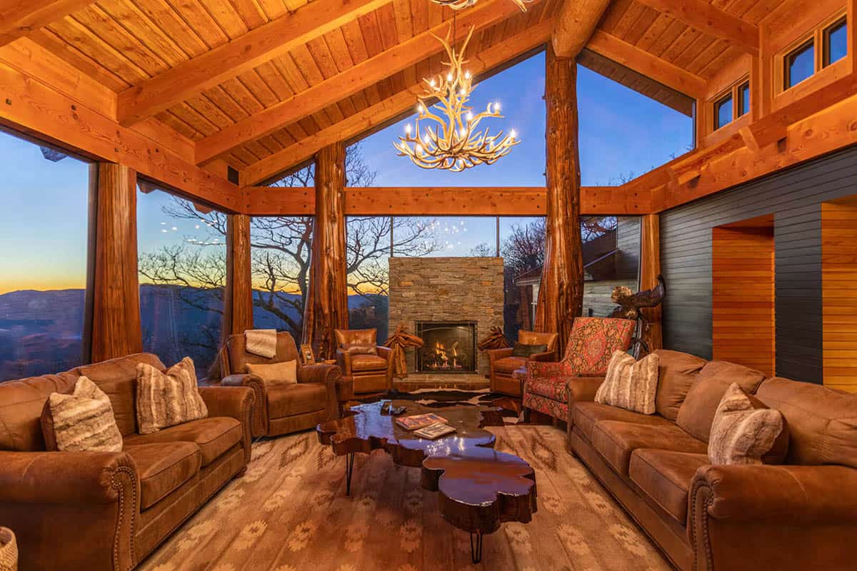 Living room at sunset with antler chandelier and tree trunk columns