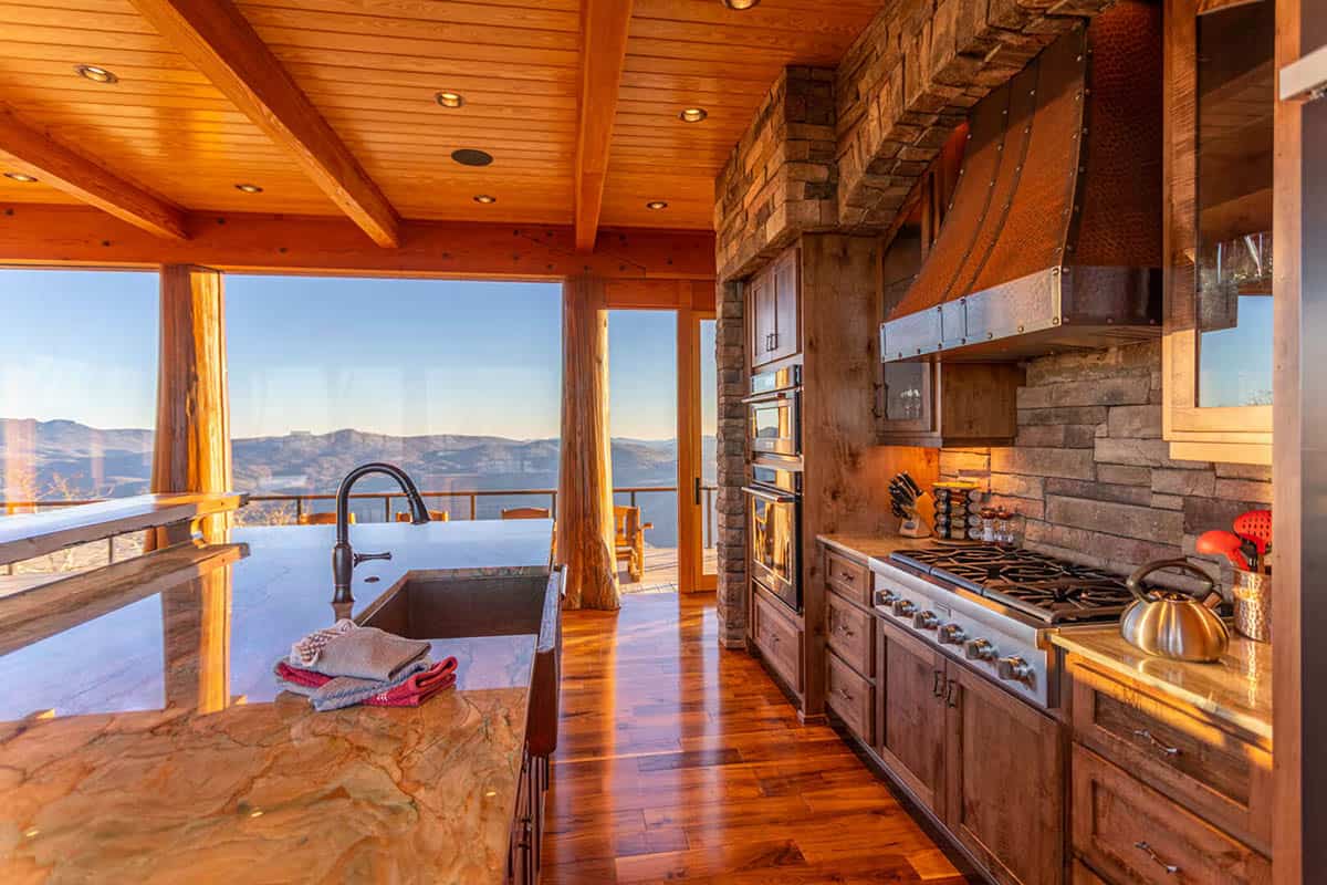 Kitchen with stone hood, gas range, and mountain valley view