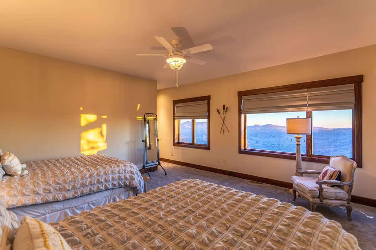 Guest bedroom with two beds and mountain view windows