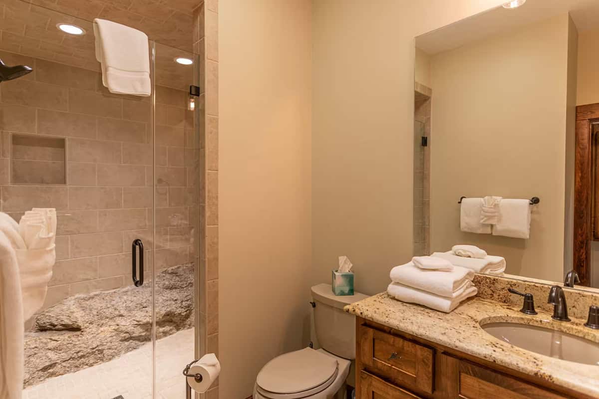 Bathroom with walk in shower and folded white towels