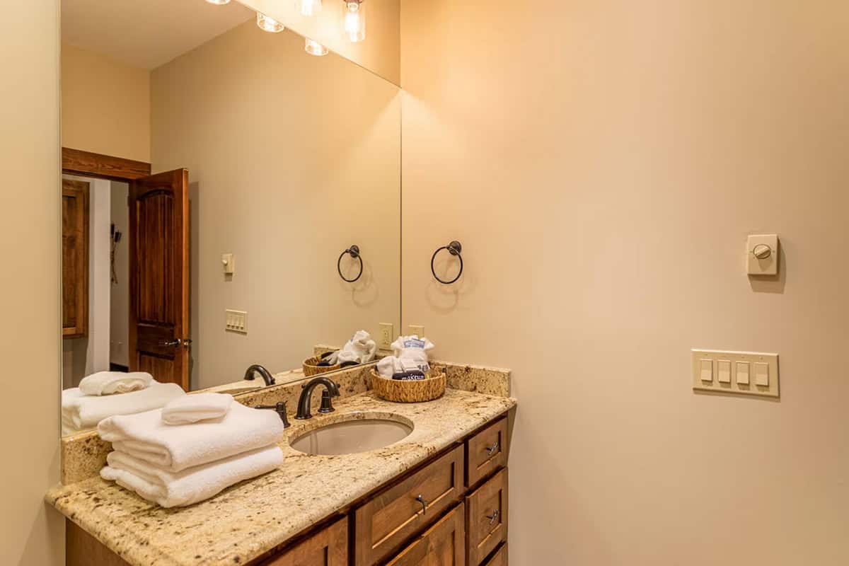 Powder room vanity with granite counter and folded towels