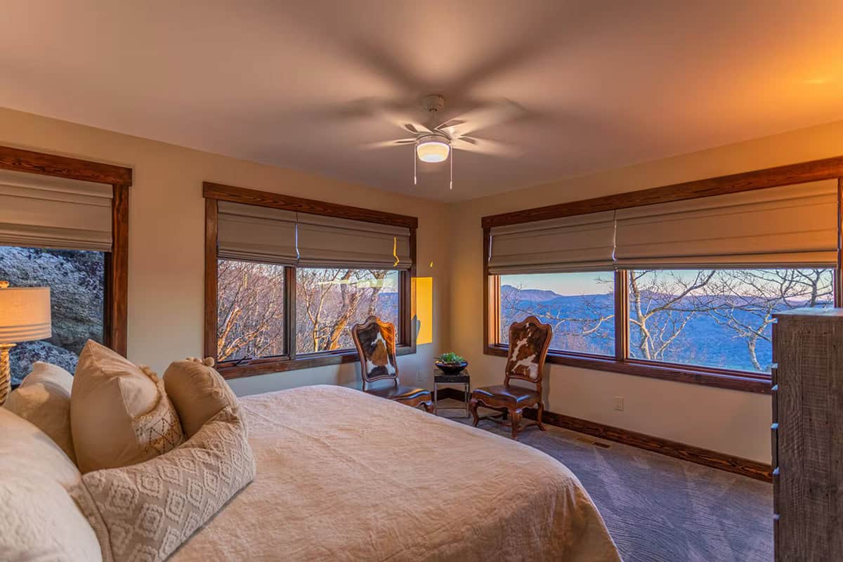 Bedroom with cowhide accent chairs and dual mountain view windows