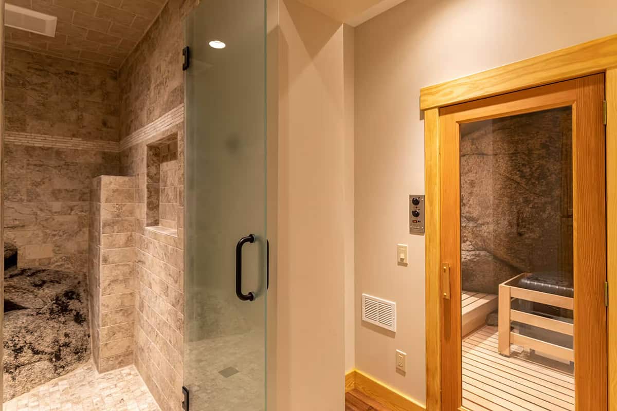 Walk in shower and sauna doorway with a natural boulder