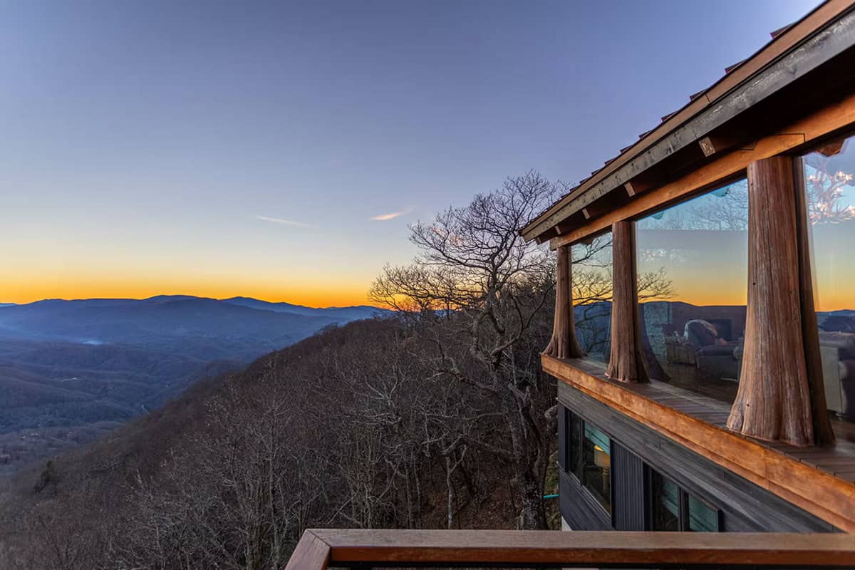 Deck corner view of the home against a sunset ridge