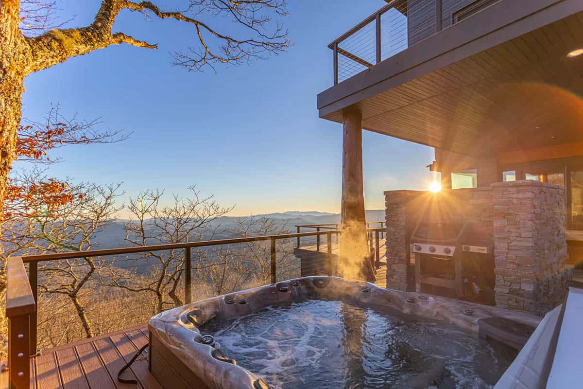 Hot tub on a deck with a mountain view at sunrise