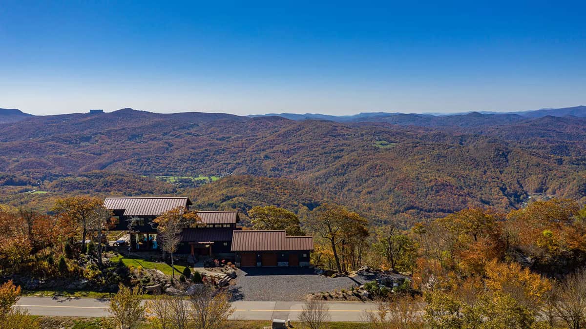 Aerial view of the mountaintop home surrounded by fall foliage