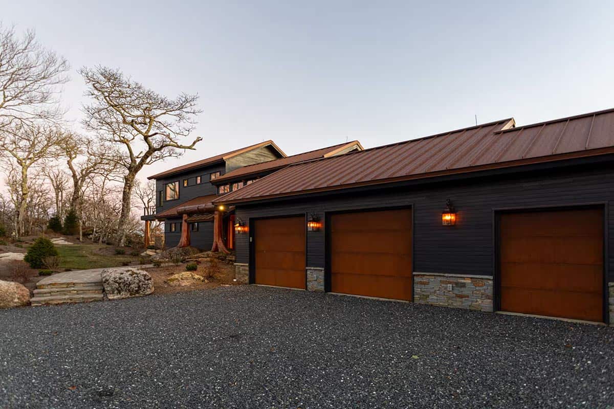 Three car garage with copper doors and a gravel driveway