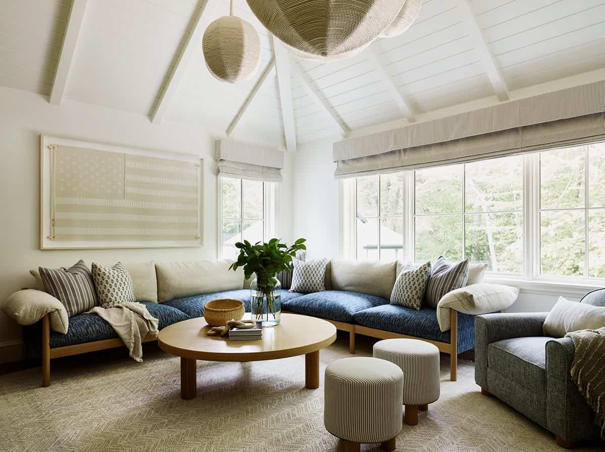 Loft sitting room with blue sectional, round coffee table, and vaulted ceiling