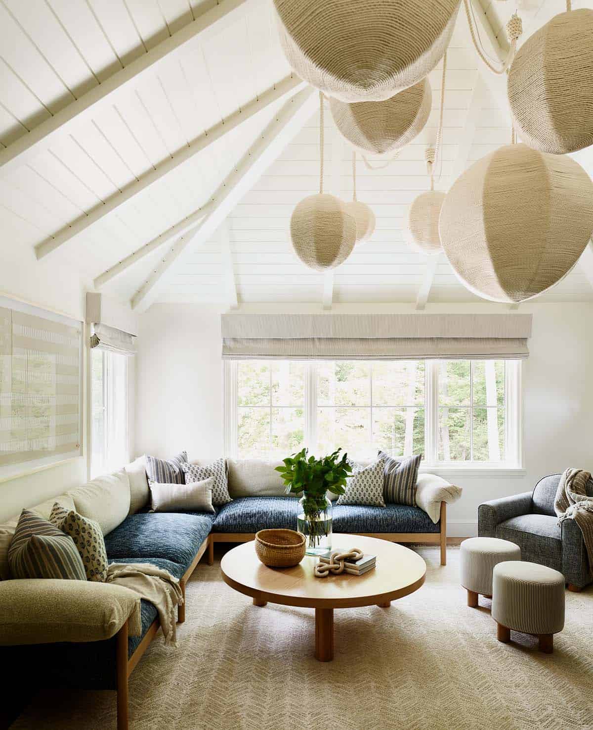 Vaulted sitting room with woven rope pendants and cozy blue sectional