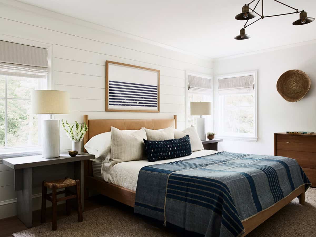 Guest bedroom with leather headboard, indigo throw, and shiplap accent wall