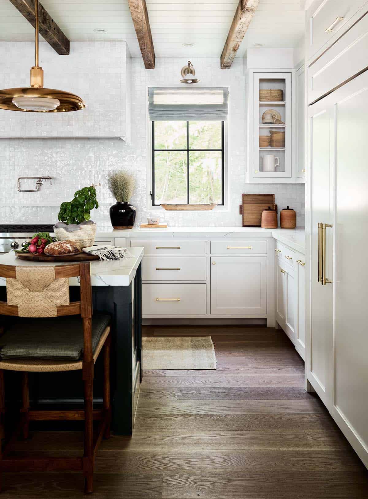 Kitchen with zellige tile backsplash, brass hardware, and dark wood island stools