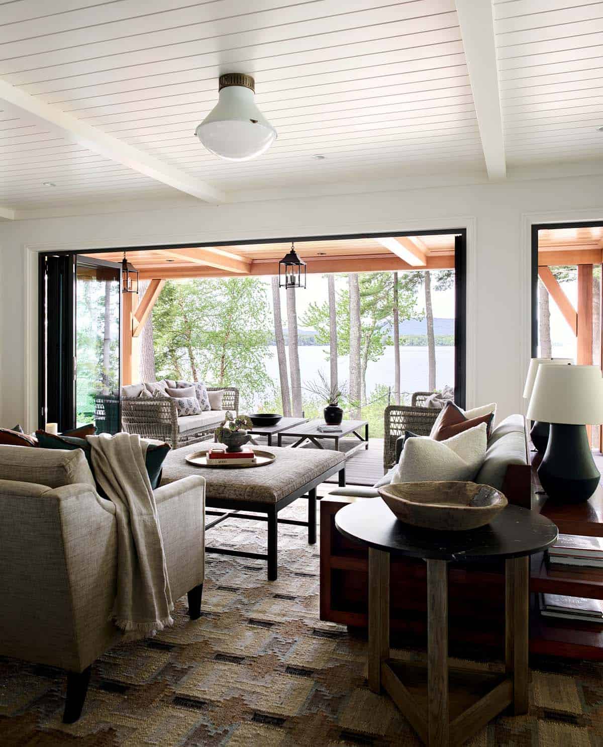 Living room with folding glass doors opening to lakeside covered porch