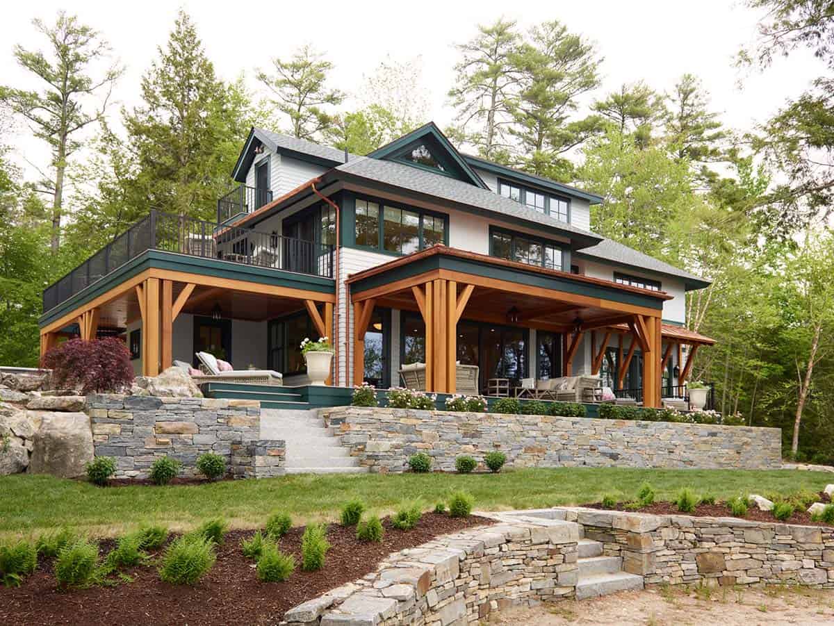 Lakeside home exterior with timber porches, stone retaining walls, and landscaping