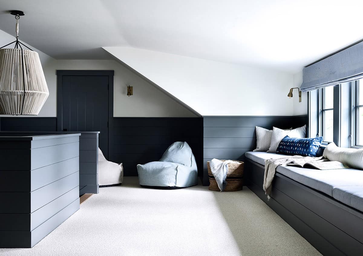 Loft lounge with navy shiplap paneling, window seat, and bean bag chairs