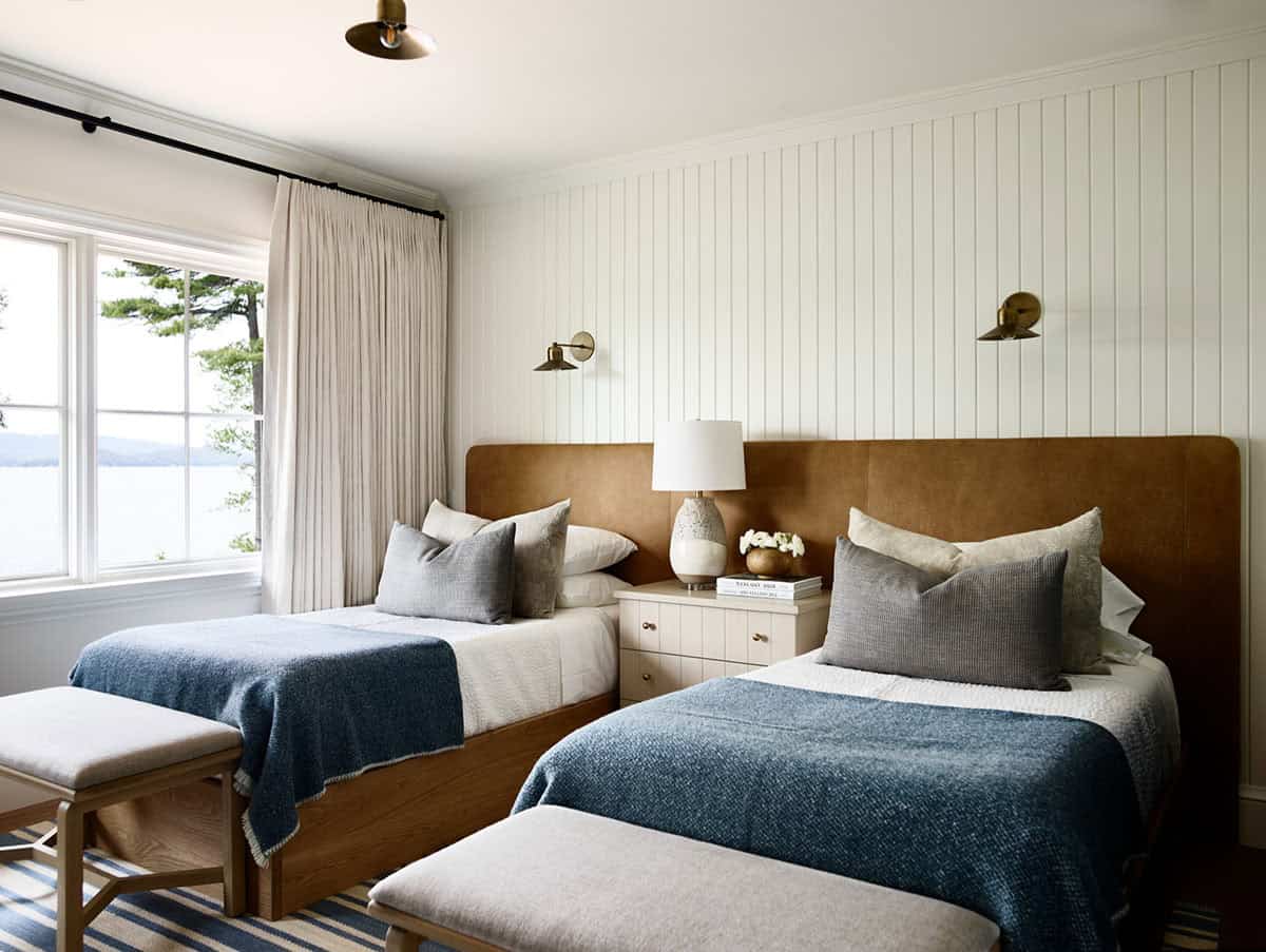 Guest bedroom with twin beds, leather headboards, and lake view window