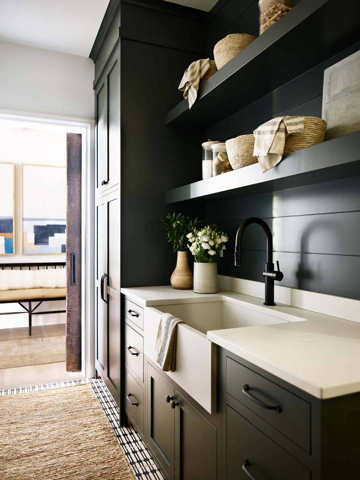 Pantry with dark green cabinets, open shelves, and farmhouse sink