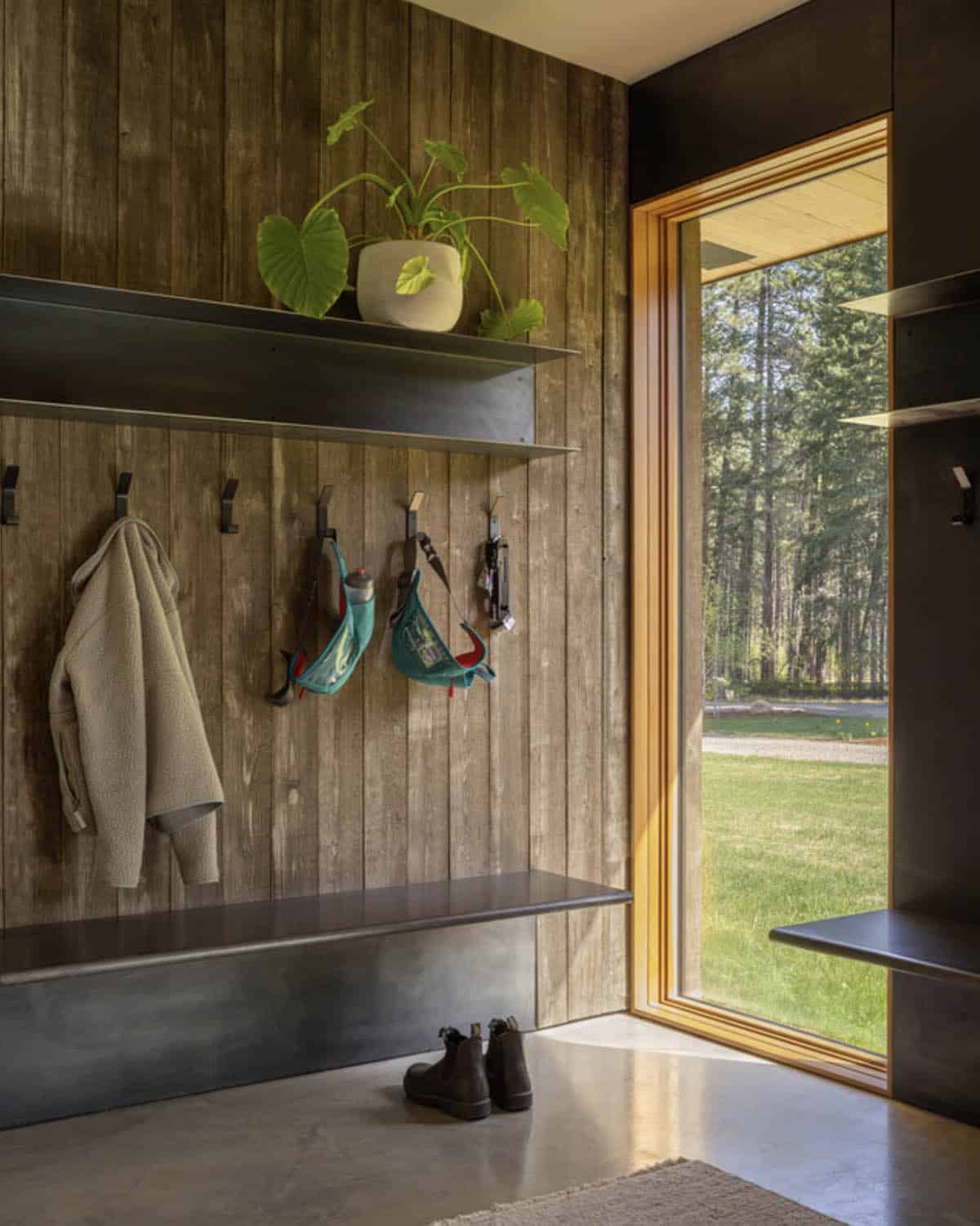 Mudroom with wood paneling, steel bench, and coat hooks