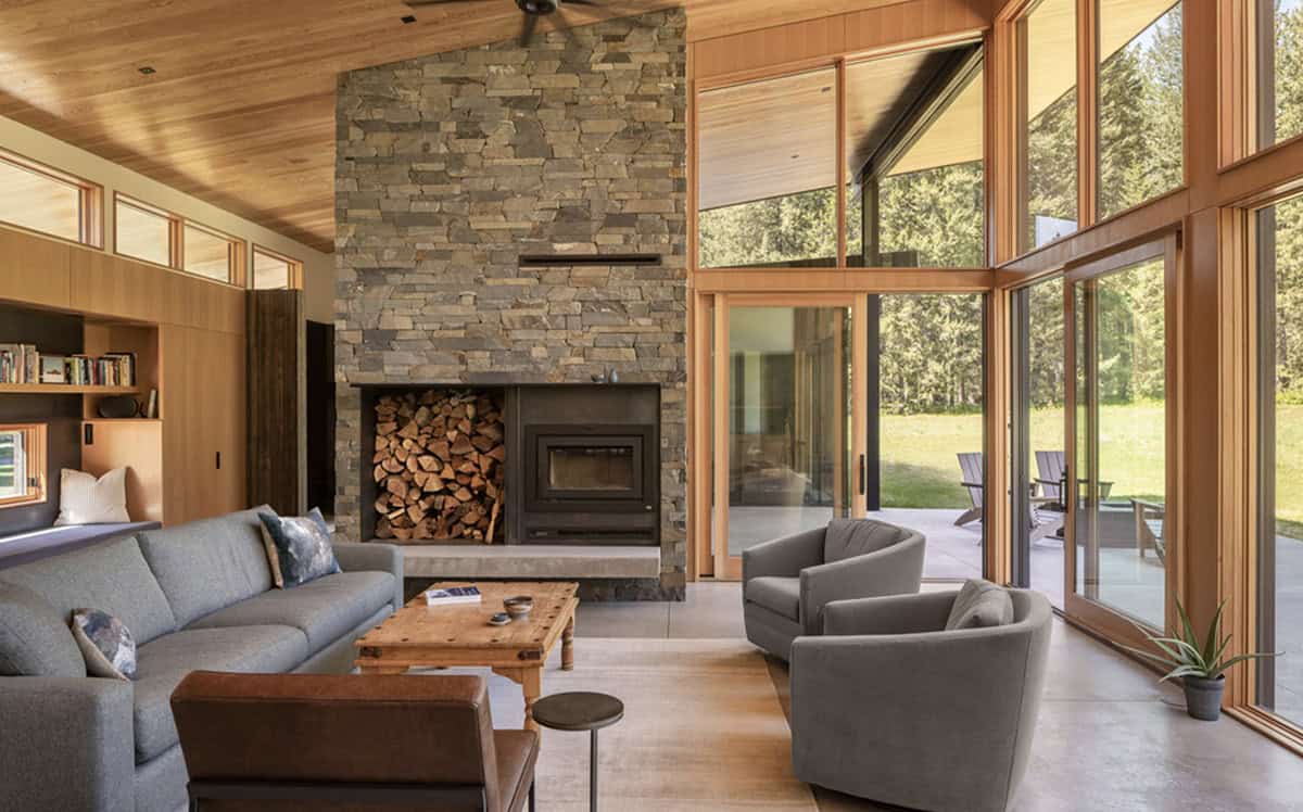 Living room with stacked stone fireplace and glass doors to patio