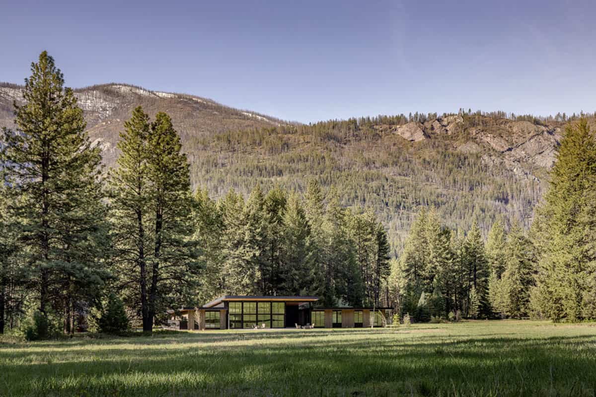 Home surrounded by trees with mountain ridge in the background