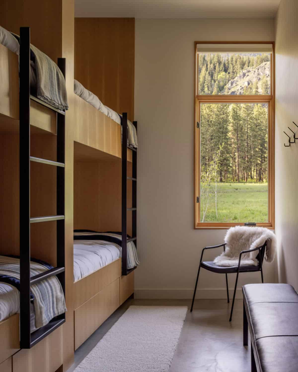 Bunk room with built-in beds and forest view window