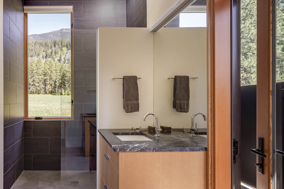 Bathroom vanity with stone tile and forest view window