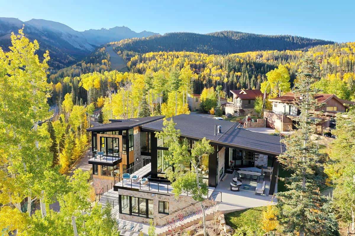 Rear exterior with layered decks framed by golden aspen trees