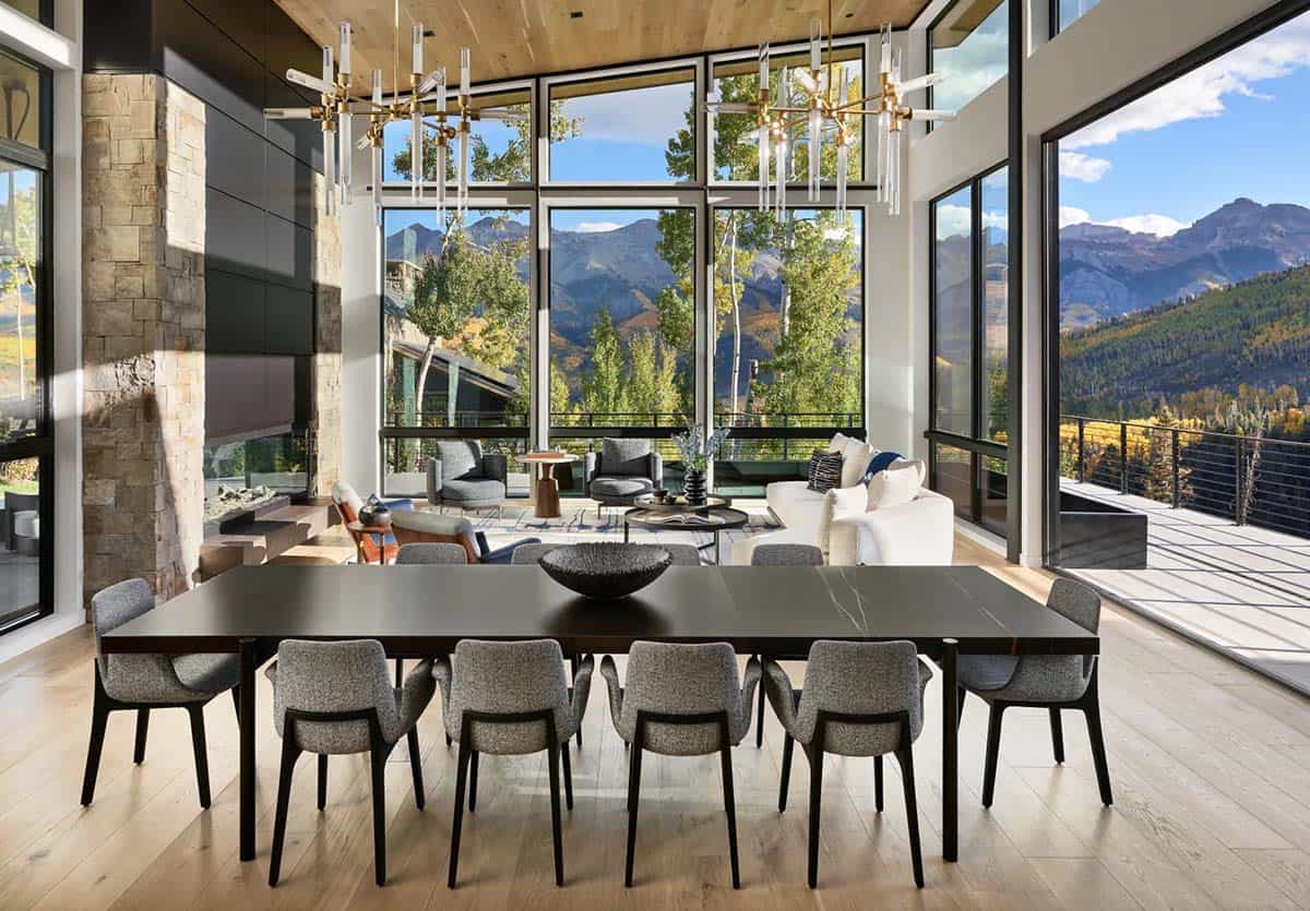 Dining area with brass chandeliers facing floor to ceiling windows