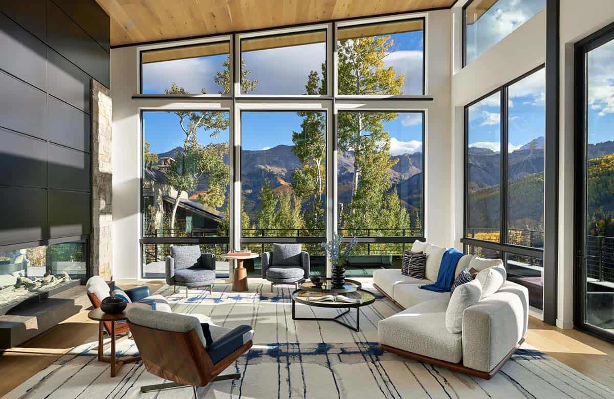 Living room seating area framed by tall mountain view windows