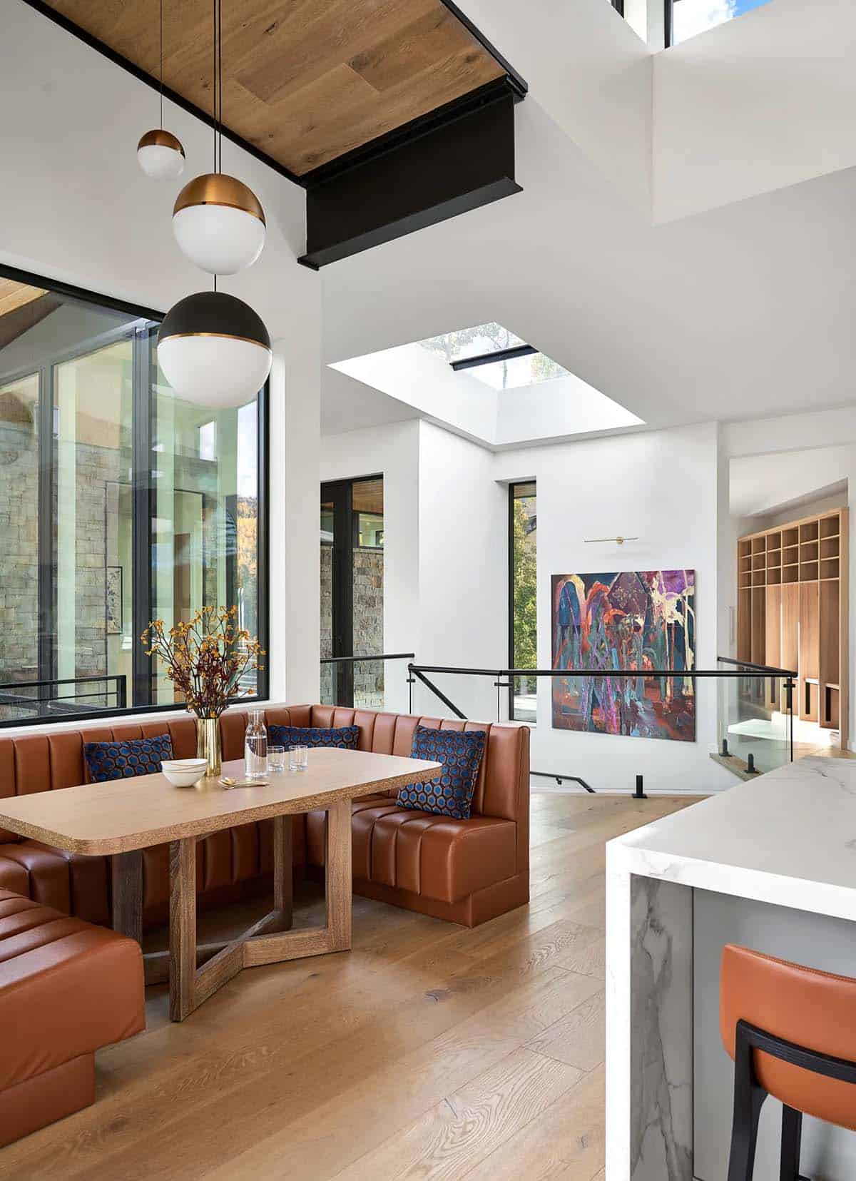 Breakfast nook with leather banquette beneath a skylight