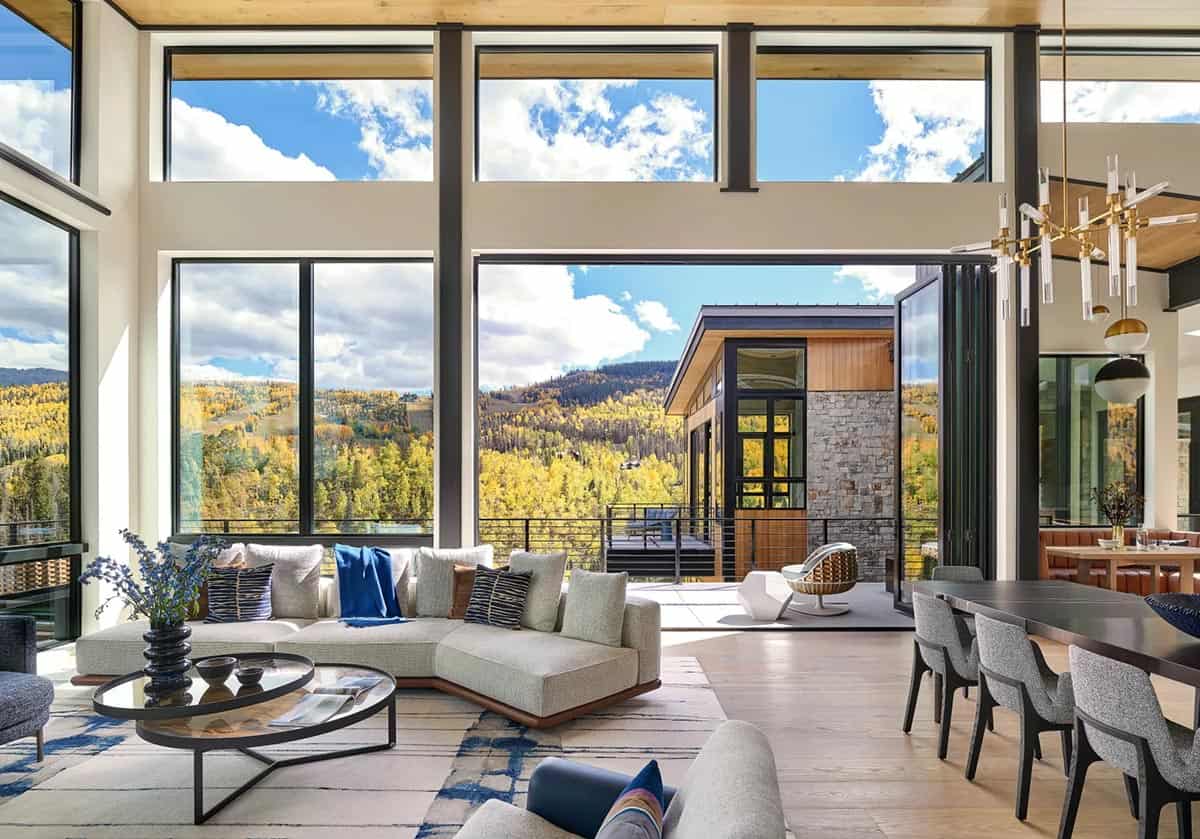 Living room opening to a covered deck with mountain views