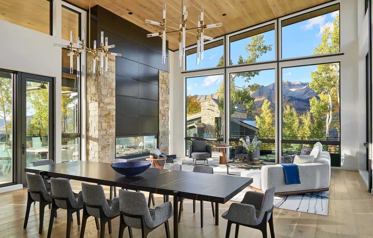 Dining and living room with stone fireplace and mountain views