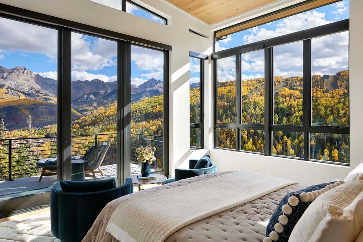 Bedroom with wraparound windows framing peaks and aspen forest