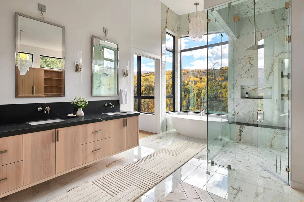 Primary bathroom with black stone counters and glass walk in shower