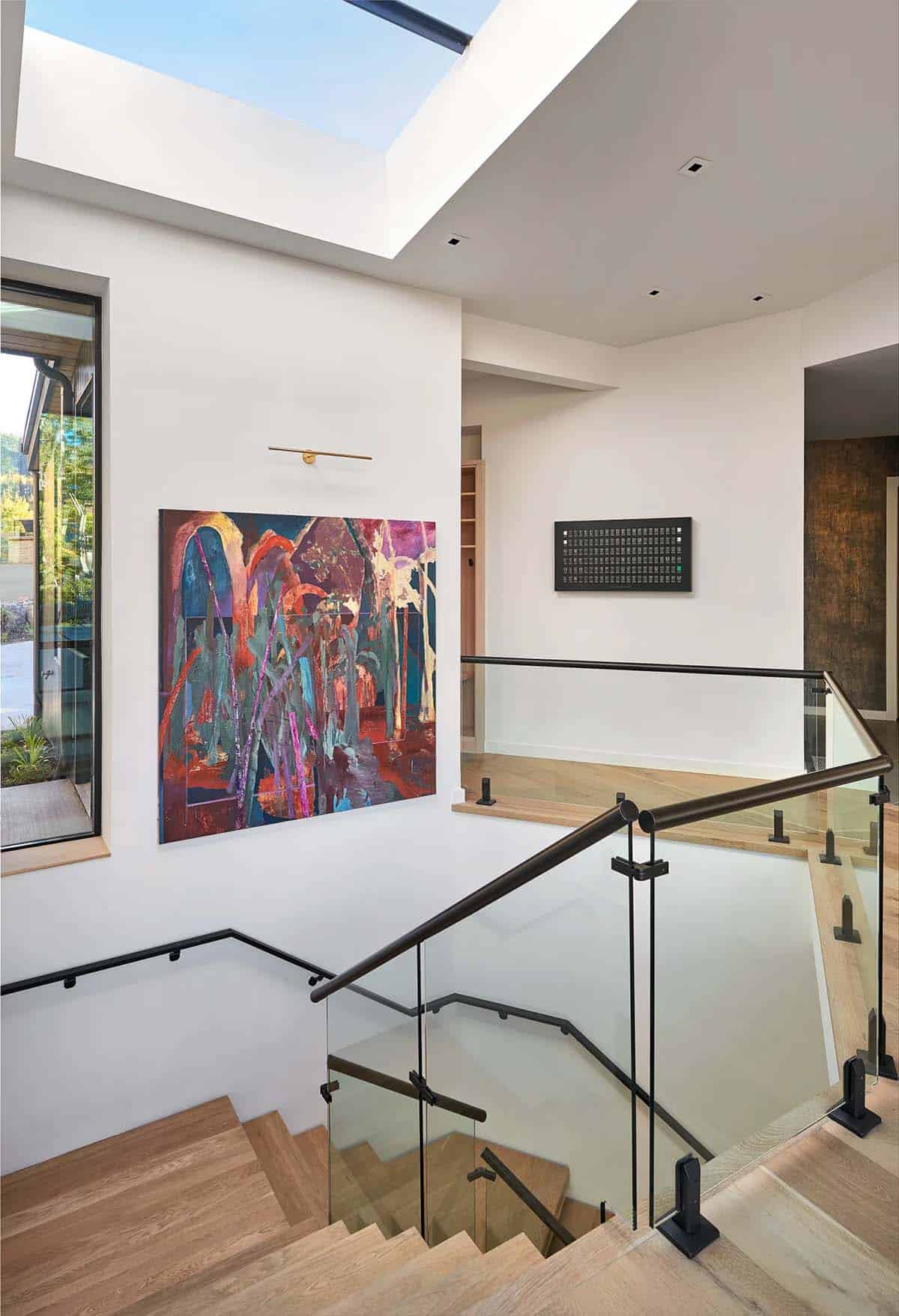 Landing with colorful abstract art and glass stair railing