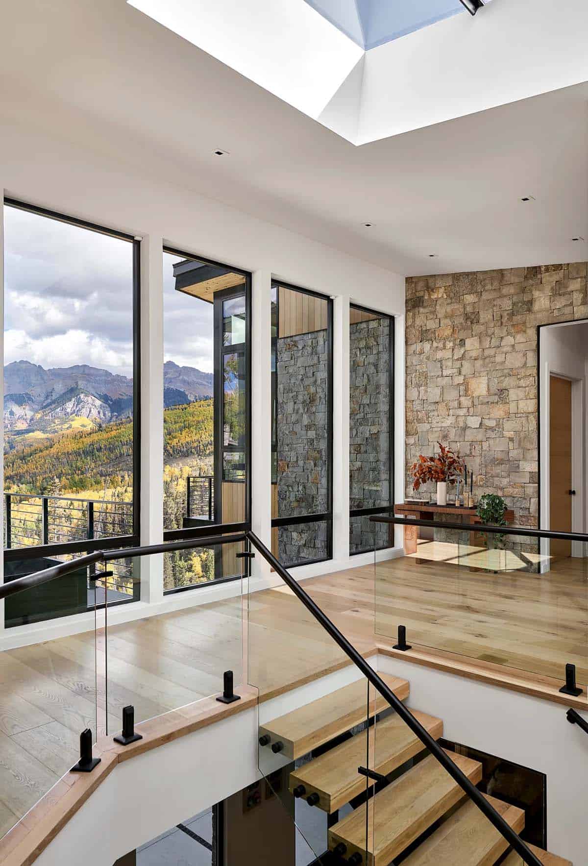 Stairwell with mountain view windows and stacked stone accent wall