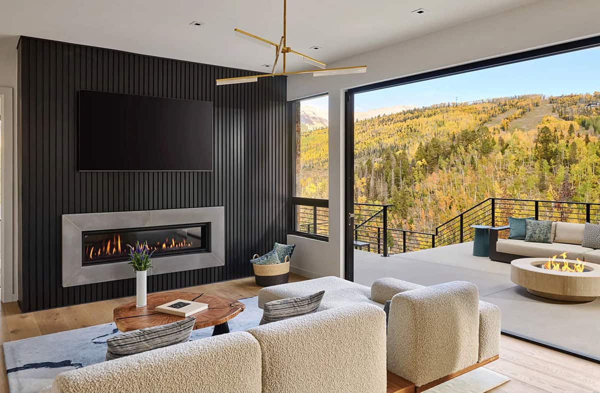 Living room with black slat wall and folding doors to deck