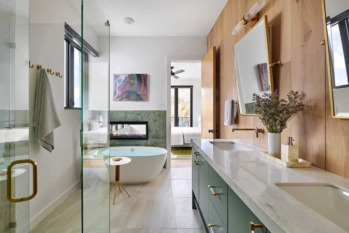 Bathroom with soaking tub, fireplace, and green stone accents