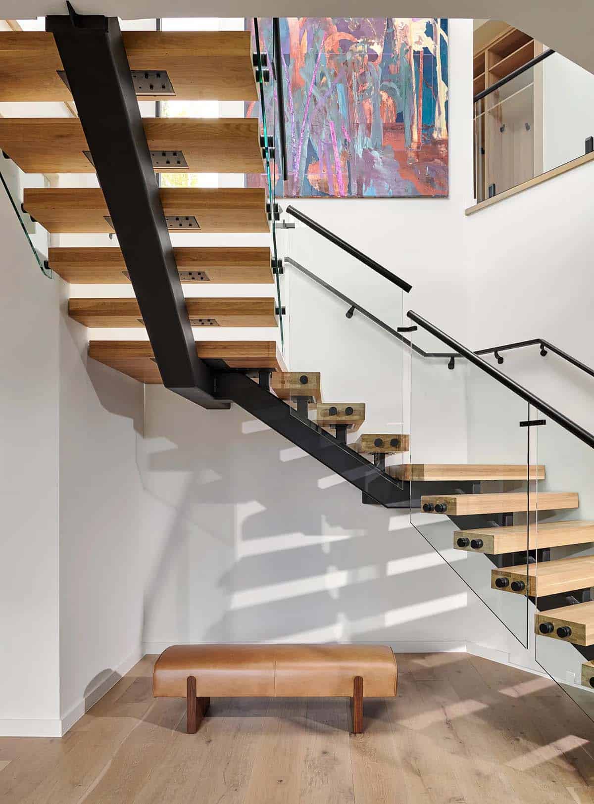Floating wood and steel staircase beneath colorful abstract art 