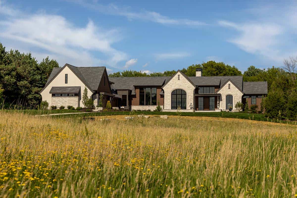 Luxury modern rambler home in Minnesota with stone facade and wildflower meadow