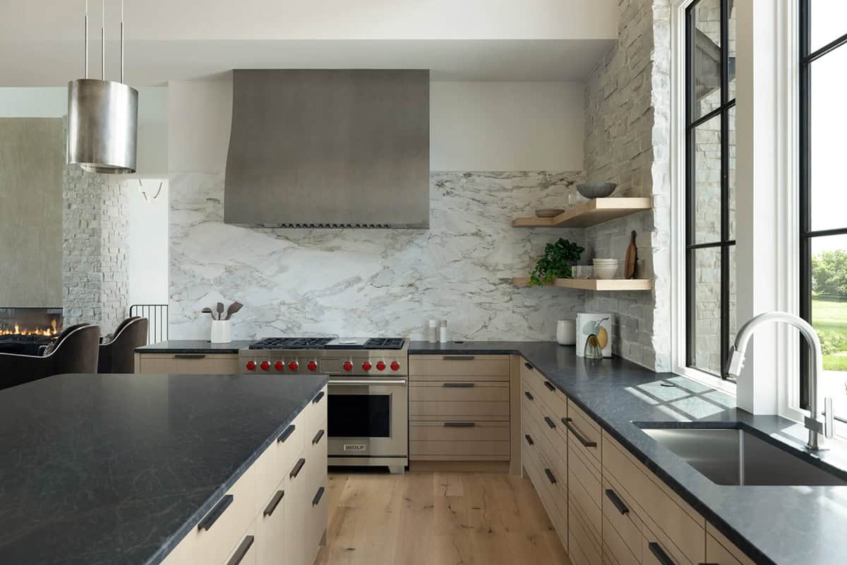 Marble slab backsplash behind professional range with stone corner shelving