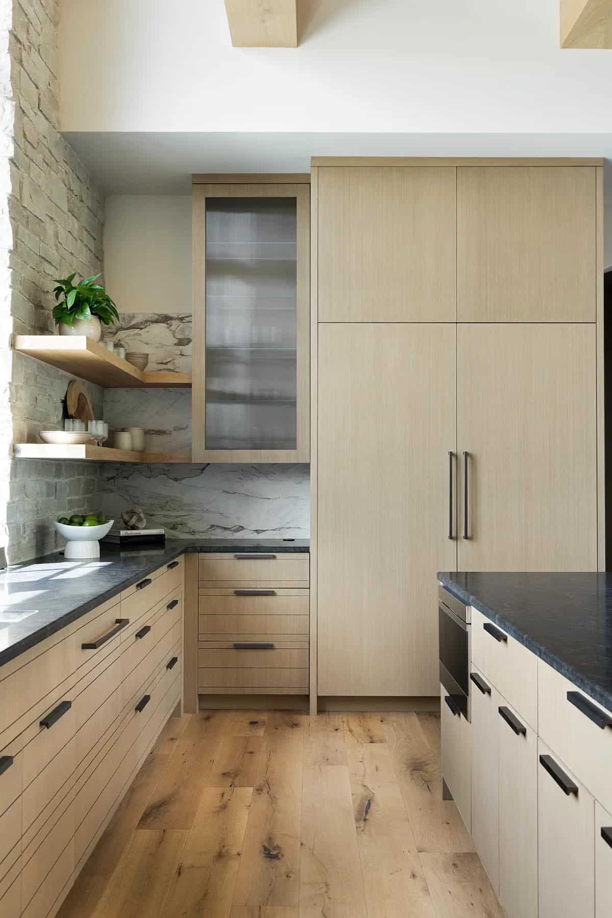 Light oak cabinetry with fluted glass cabinet and paneled refrigerator
