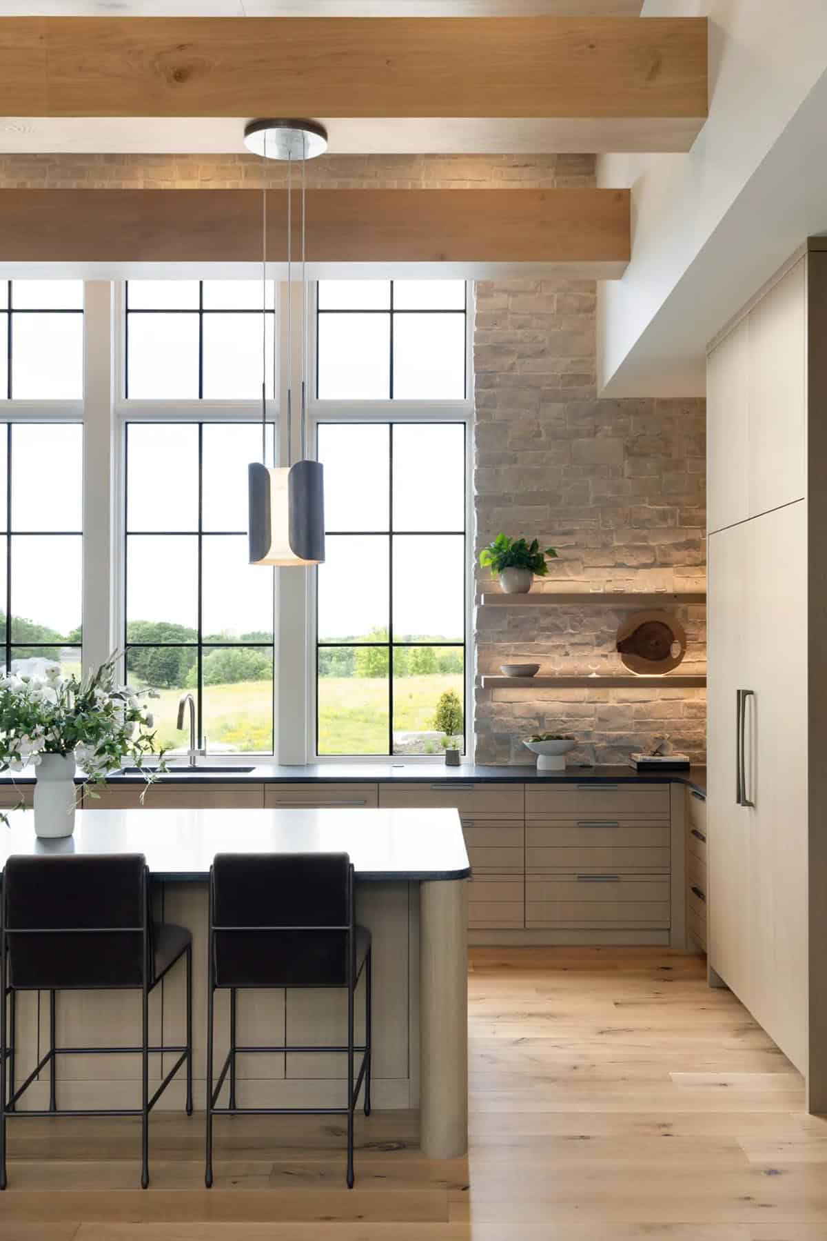 Warm lighting glowing across stone wall and floating shelves in kitchen