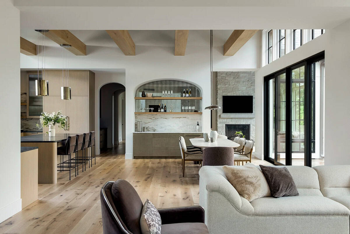 Open kitchen, arched wine nook, and dining area under exposed wood beams