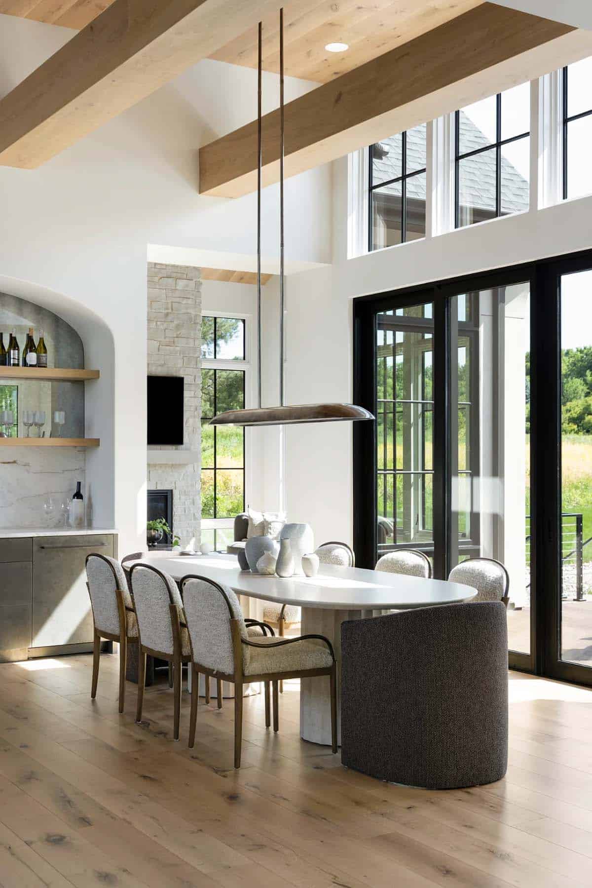 Dining area with arched bar nook, sliding glass doors, and wood beams