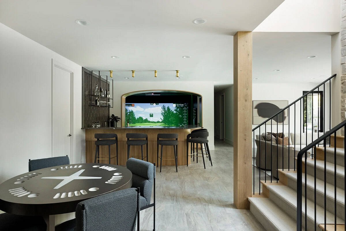Lower level bar with golf simulator, round game table, and oak column