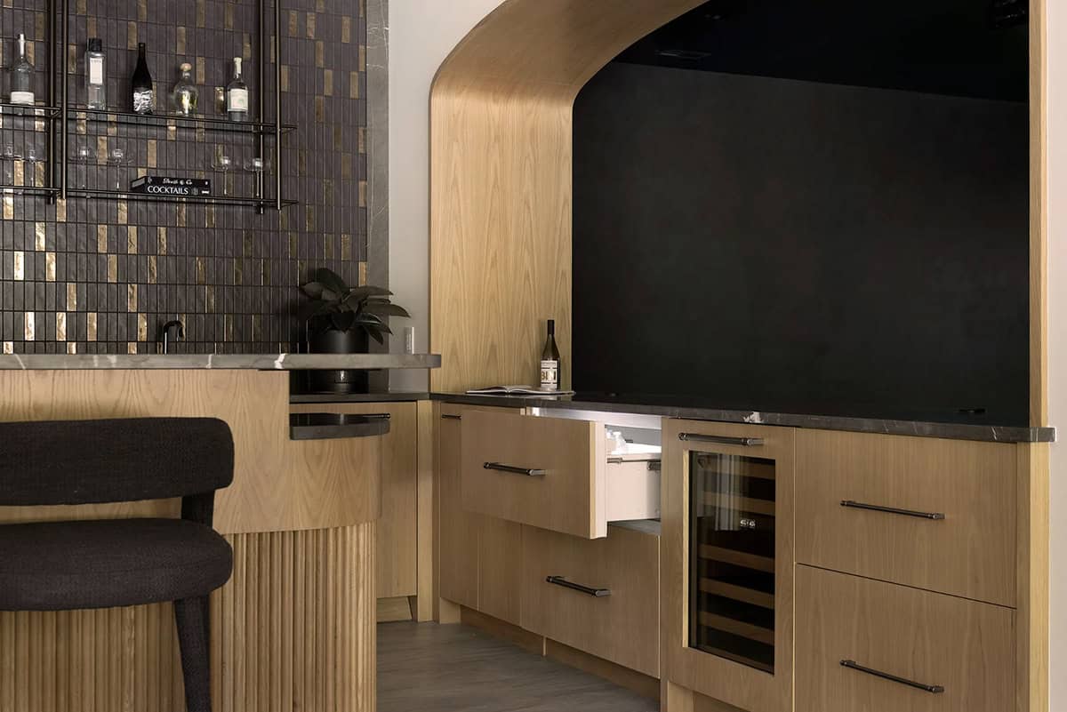 Arched oak nook with wine refrigerator and light oak bar cabinetry