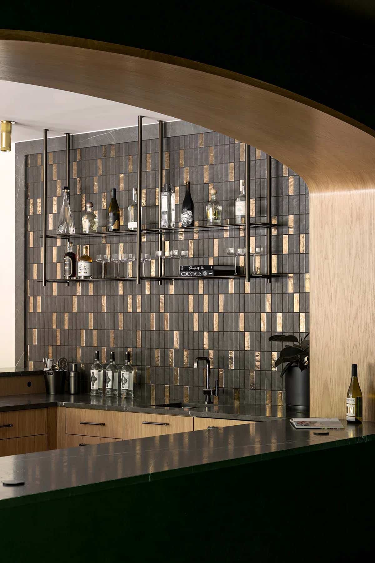 Curved oak arch framing bar shelves with liquor bottles and coupe glasses