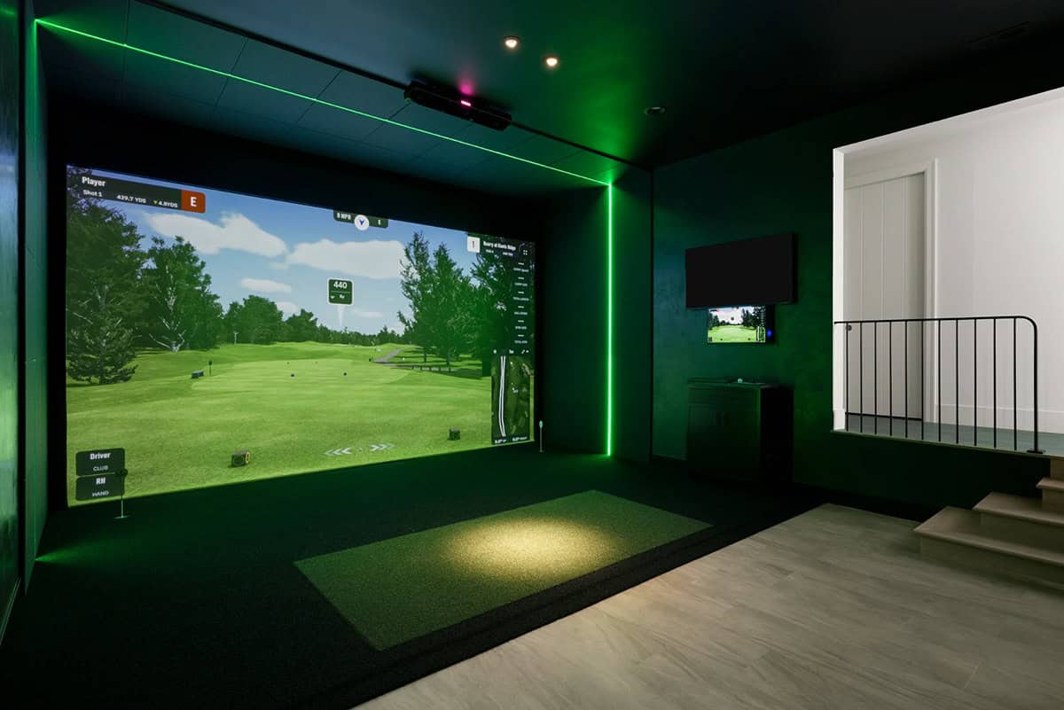 Golf simulator room with green accent lighting and large projection screen